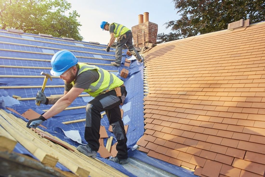 Workers tiling a roof