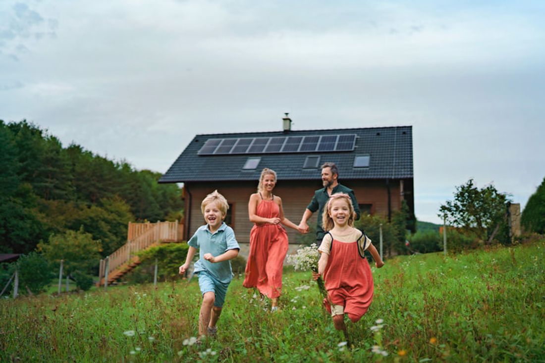 A family in front of their solar-powered home