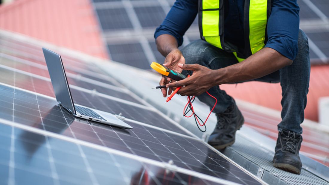 Service engineer checking solar cell on the roof for maintenance