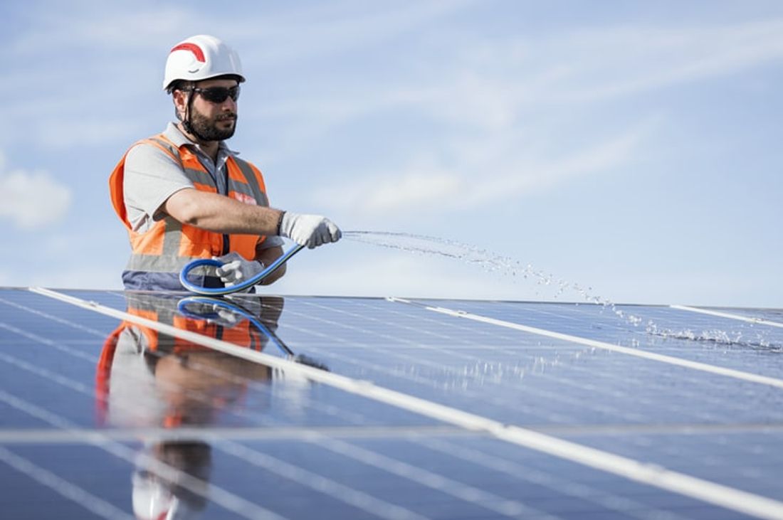 Man cleaning solar panels