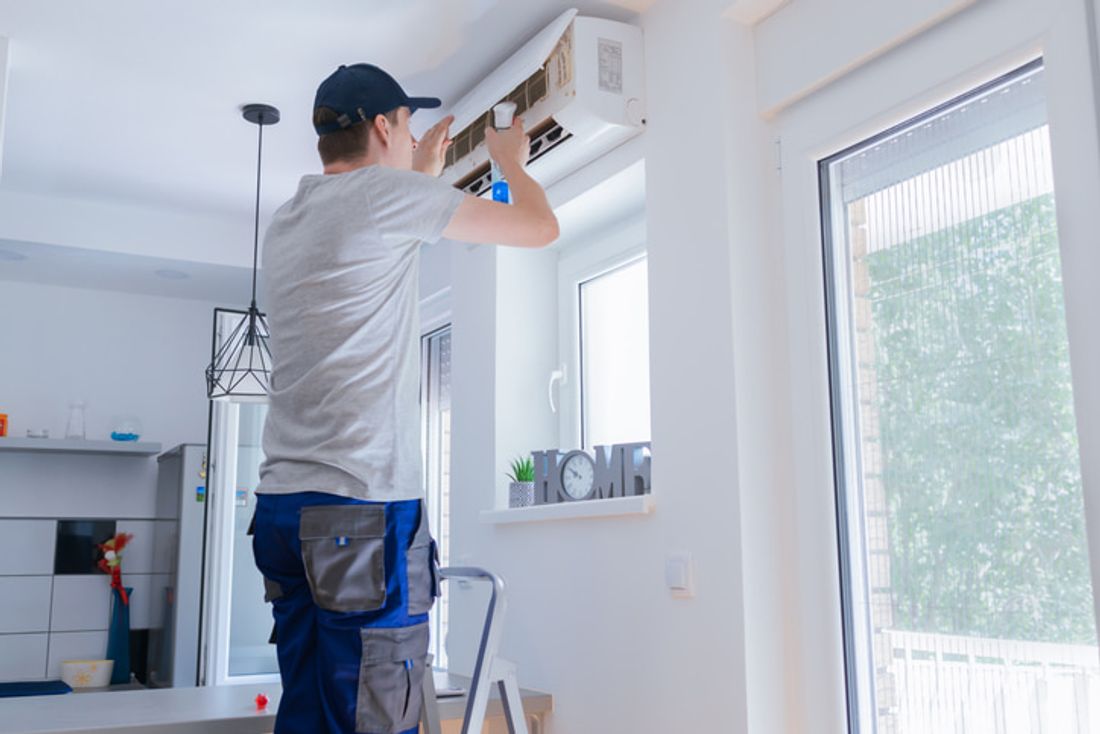 Tradie cleaning a split type aircon
