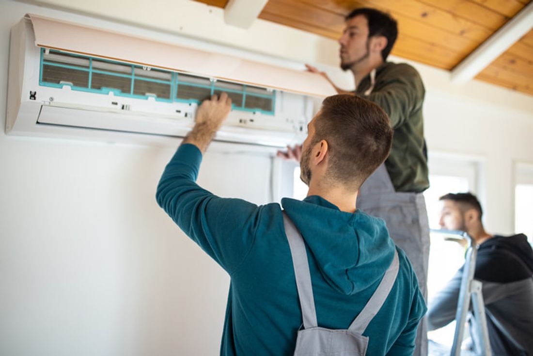 Tradies performing aircon maintenance