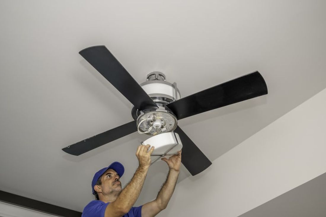 Professional ceiling fan installation work in progress