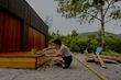 woman sealing a rustic timber patio