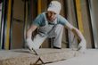 man installing insulation in a home